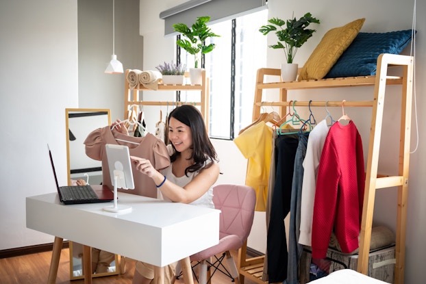 Woman doing a livestreamed video selling clothing.