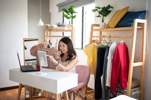  Woman doing a livestreamed video selling clothing.