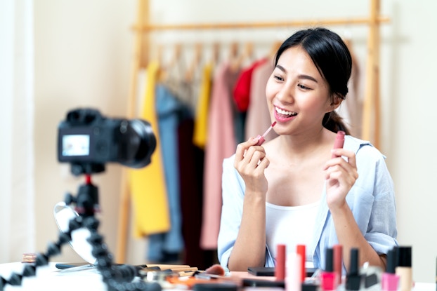 female influencer recording a video putting on makeup