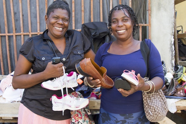  two women holding shoes for soles4souls