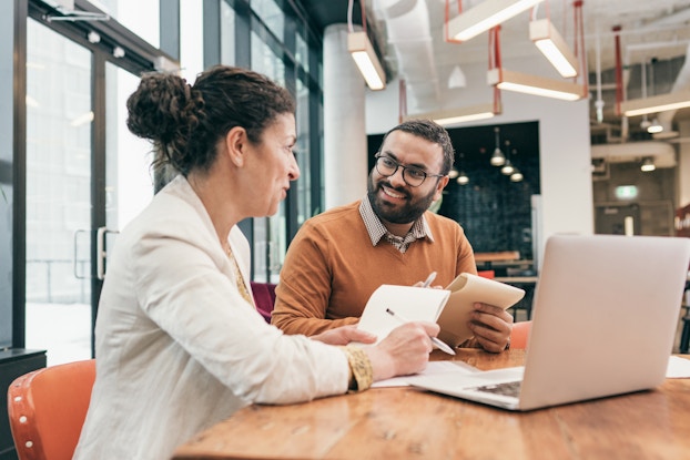Two people going over business paperwork in an office.
