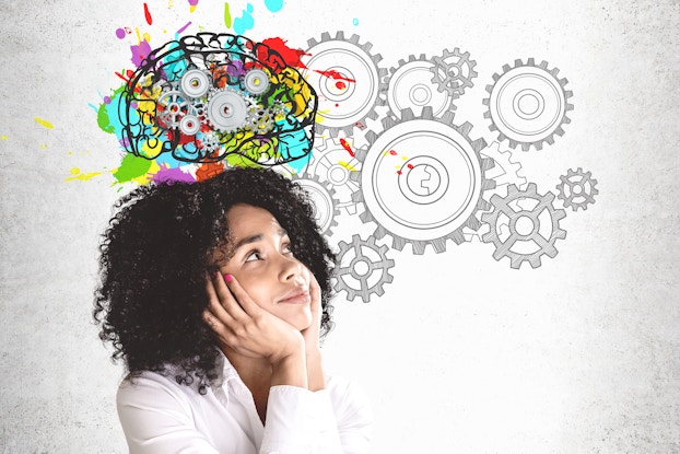 woman smiling brainstorming with wheels turning in the background