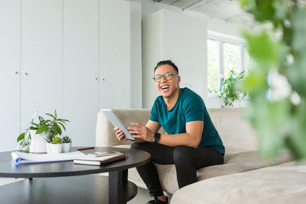  Smiling man working on tablet.