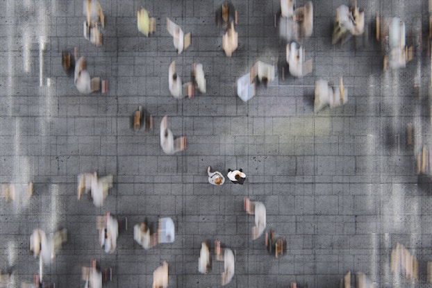businesspeople standing in a busy street of commuters