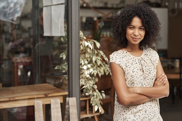confident woman business owner standing outside a storefront