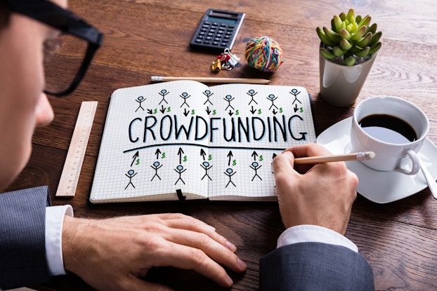 man drawing crowdfunding images in notebook