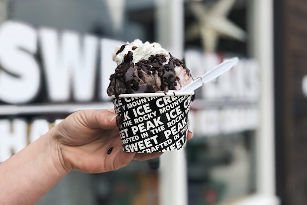 Person holding up an ice cream cup from Sweet Peaks Ice Cream.
