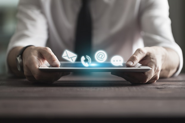 man holding tablet with communication icons