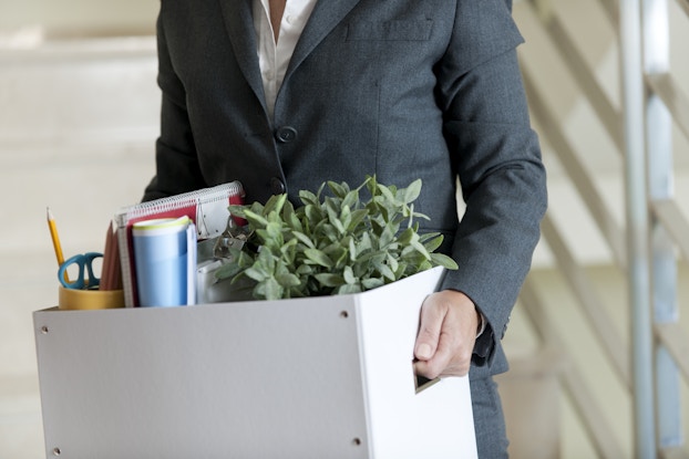  man in suit with packed box of office belongings