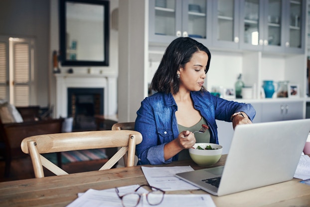  woman working from home checking her watch