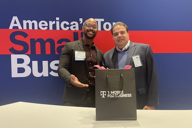  Event attendee Carlos Walter poses with a T-Mobile representative after winning a new iPhone.