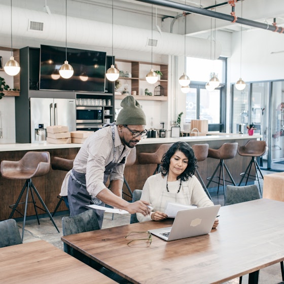 two people inside their business working on a laptop