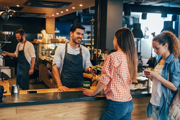 Woman paying with credit card at a cafeteria.