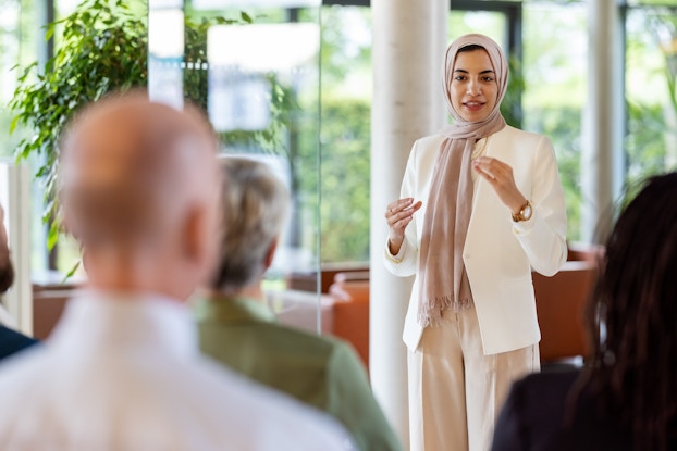  Woman speaking to a group of people.