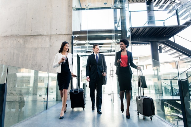  three coworkers walking with suitcases