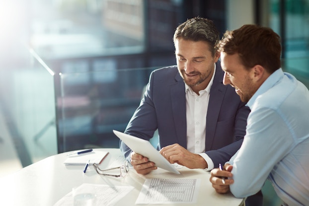 two men in business meeting reviewing paperwork
