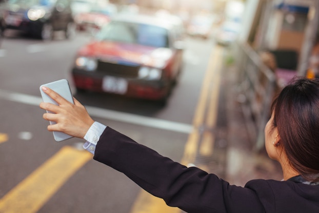 girl hailing uber with phone