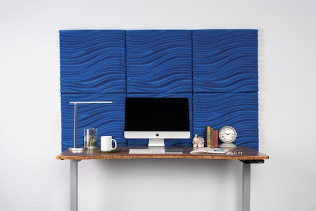 uplift desk's acoustic 3d wave wall panel behind computer desk