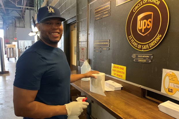  UPS employee cleaning surface at work