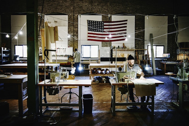  Person working inside a business with an American flag hanging in the background.