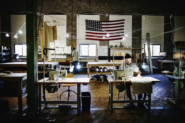 Person working inside a business with an American flag hanging in the background.