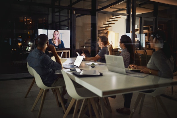 people having video conference at a table