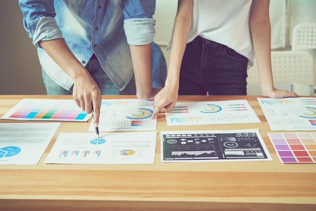  two people looking at charts on a table