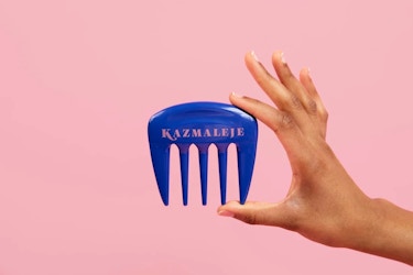  Hand holding a blue hairbrush by Kazmaleje. 