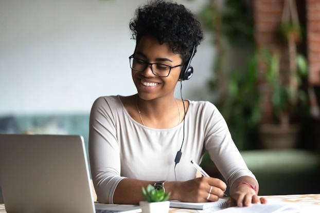  woman on webinar call taking notes