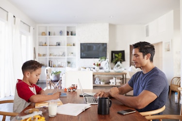  father working at kitchen table with son 