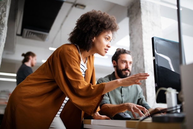  Female business owner consults male colleague.