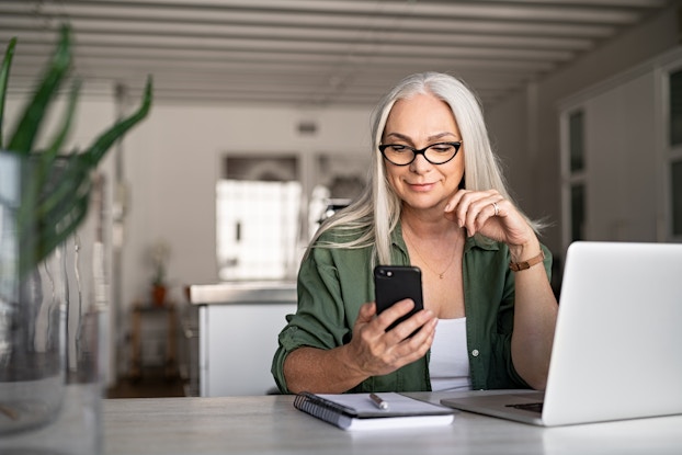  woman on phone and laptop working from home