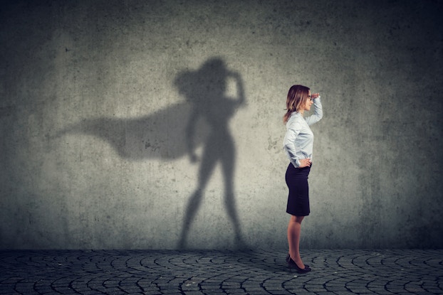  woman standing with superhero shadow