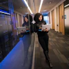 a woman standing in a hallway with a tablet