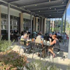 a group of people sitting at tables outside