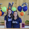 two women standing in front of balloons