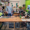 a man standing in front of a counter with a sign