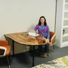 a woman sitting at a table with a laptop
