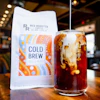 a glass of iced coffee with a bag of coffee