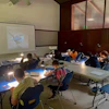 a group of kids sitting at tables in a classroom