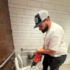 a man using a drill to drill a toilet