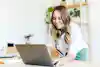 Woman smiling at her laptop while working remotely.